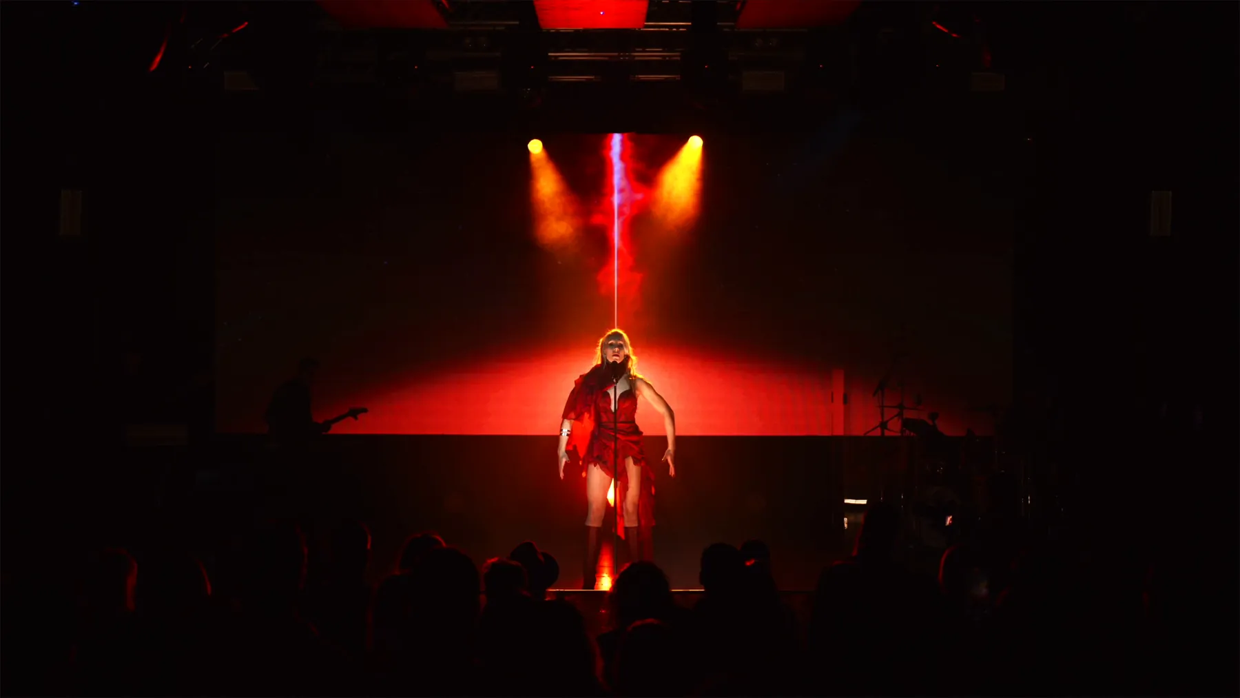 KING IV walking forward on a red-lit stage